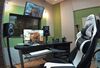 Gaming chair with monitors and speakers on a desk in front of it